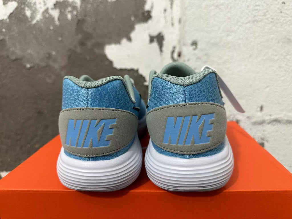 Rear view of blue Nike sneakers with gray heel panels and white ridged soles