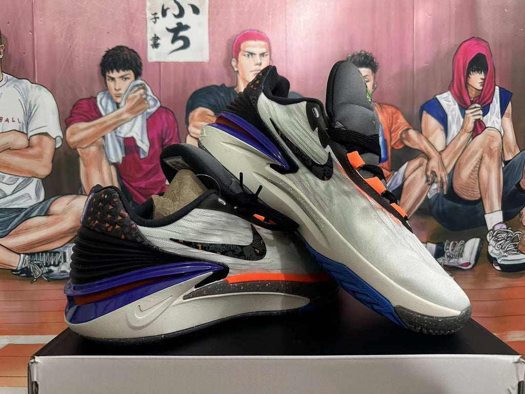 Angled view of the pair highlighting purple heels, orange accents, and dark outsoles