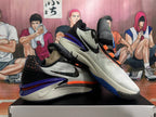 Angled view of the pair highlighting purple heels, orange accents, and dark outsoles
