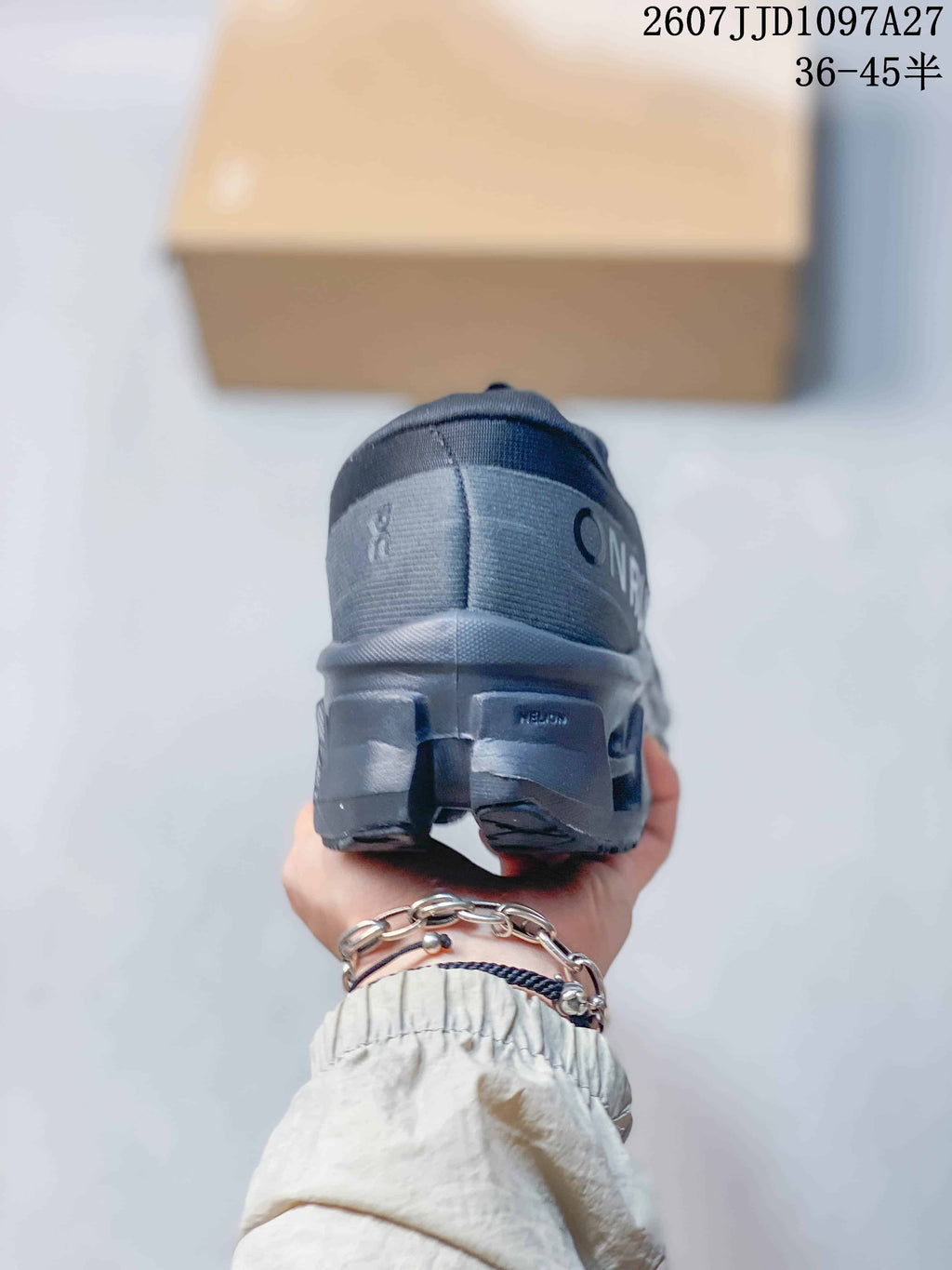 Rear view of the dark gray sneaker showing the padded heel, On branding, and sculpted outsole.