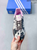 Top view showing the cow-print toe box, dark laces, pink lining and adidas tongue label.
