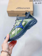 Side profile showing the layered green and navy upper, structured midsole, and textured outsole.