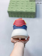 Rear view of the sneaker showing the white thick sole, navy heel panel and red padded heel tab.