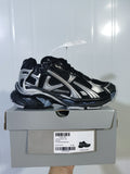 Black and silver Nike Runner sneaker displayed on its shoe box; the box label shows Runner, Black/Silver, and EU 40.
