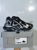 Black and silver Nike Runner sneaker displayed on its shoe box; the box label shows Runner, Black/Silver, and EU 40.