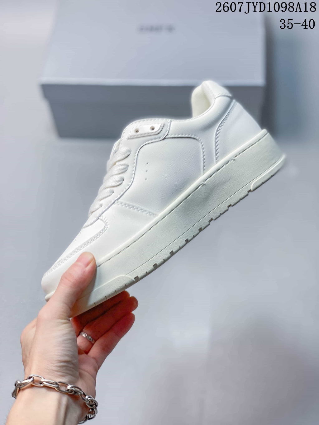 Side view of the white sneaker showing the panelled upper, padded collar, and thick tonal outsole.