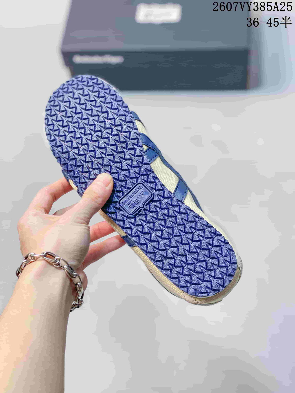 Underside of the sneaker showing the blue textured outsole and molded Onitsuka Tiger branding.