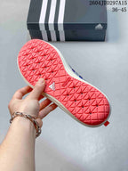 Close view of the coral outsole showing a geometric traction pattern and Adidas branding.