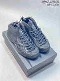 Pair of gray Nike Air Foamposite Pro-style high-top shoes shown on a box
