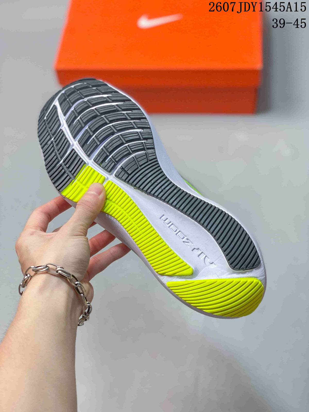 Close view of the Nike Zoom Winflo 8 outsole showing black tread sections, lime green traction areas, and a white midsole.