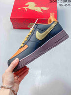Side view of a navy and orange low-top sneaker with gold-tone side detail and burgundy-colored sole