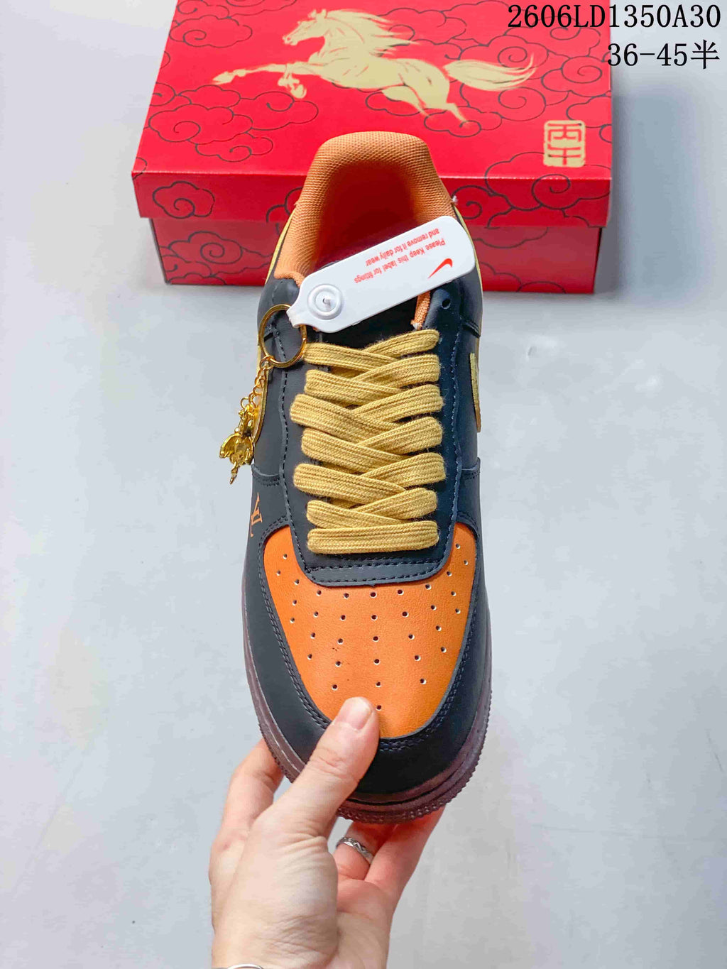 Top view of orange perforated toe, dark navy overlays, and wide yellow laces