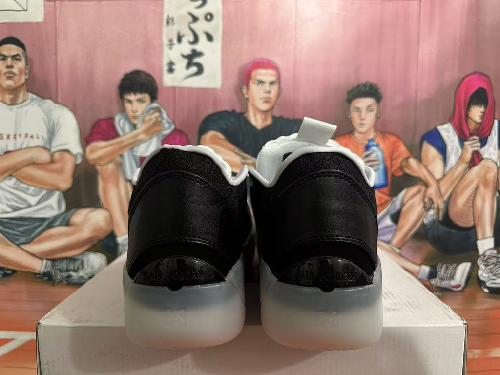 Rear view of black and white Jordan basketball shoes showing heel panels and translucent-looking outsole sections.