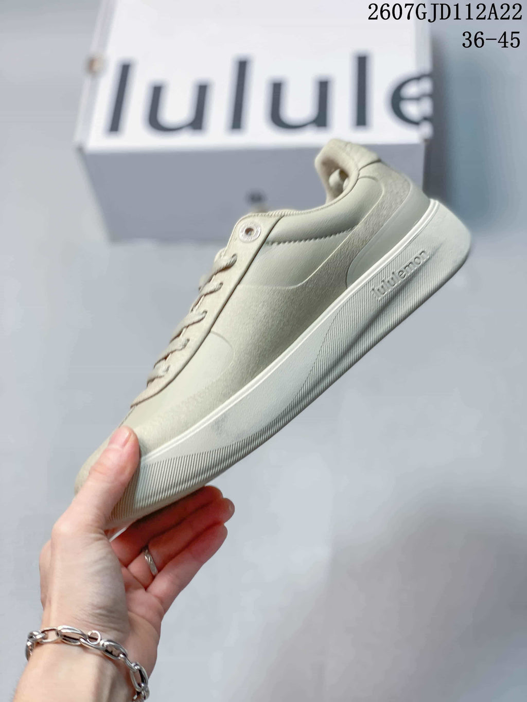Side profile of a light neutral lululemon low-top sneaker showing the layered upper, lace area and flat sole.