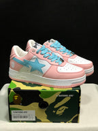 Pair of pink, white, and light-blue Bape Sta sneakers displayed on a camouflage BAPE box; the box label shows EU 41 and CM 26 for the photographed sample.