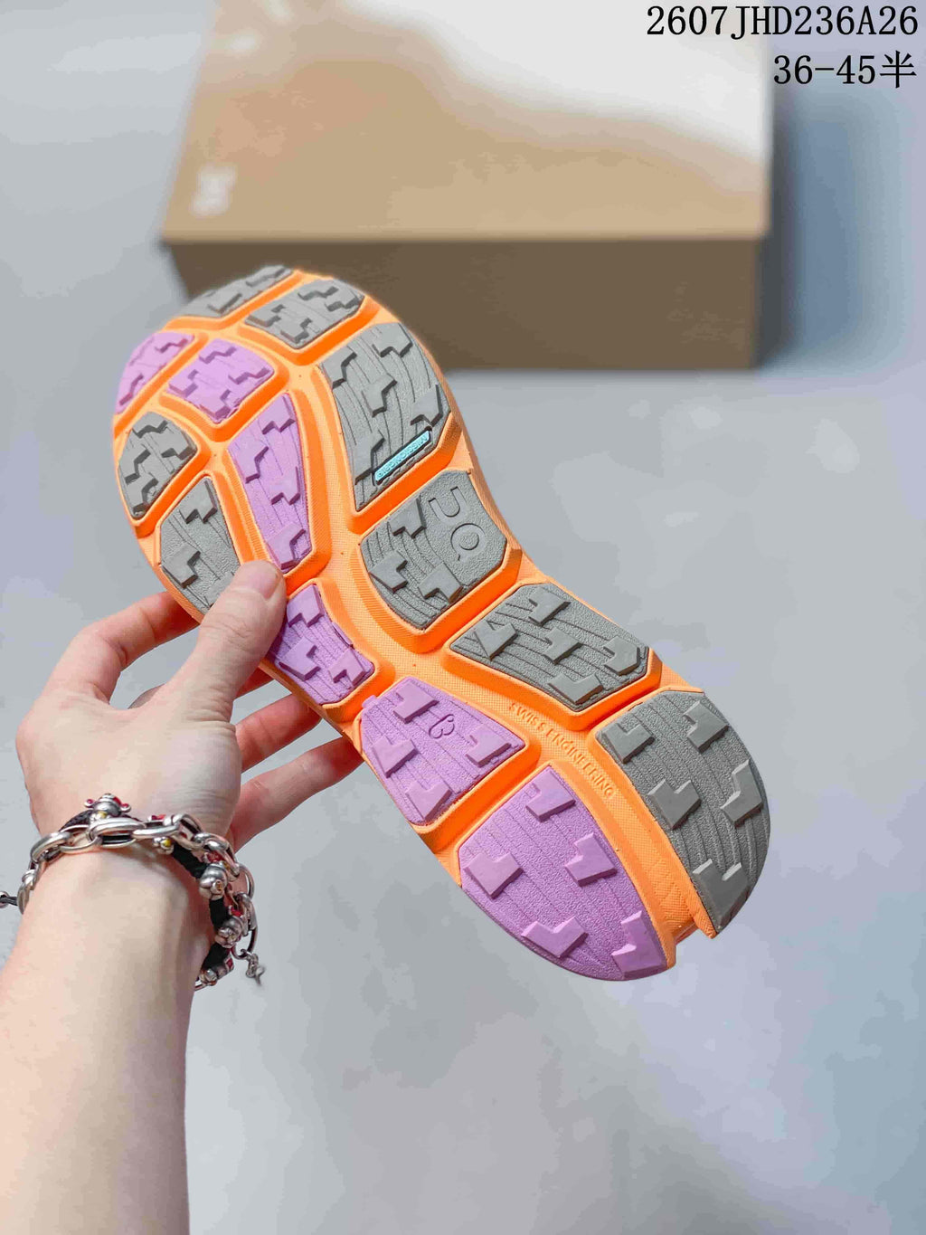 Close view of the shoe outsole showing gray and purple lugged rubber sections.