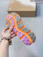 Close view of the shoe outsole showing gray and purple lugged rubber sections.