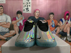 Front view of silver holographic basketball shoes with black laces and turquoise outsoles