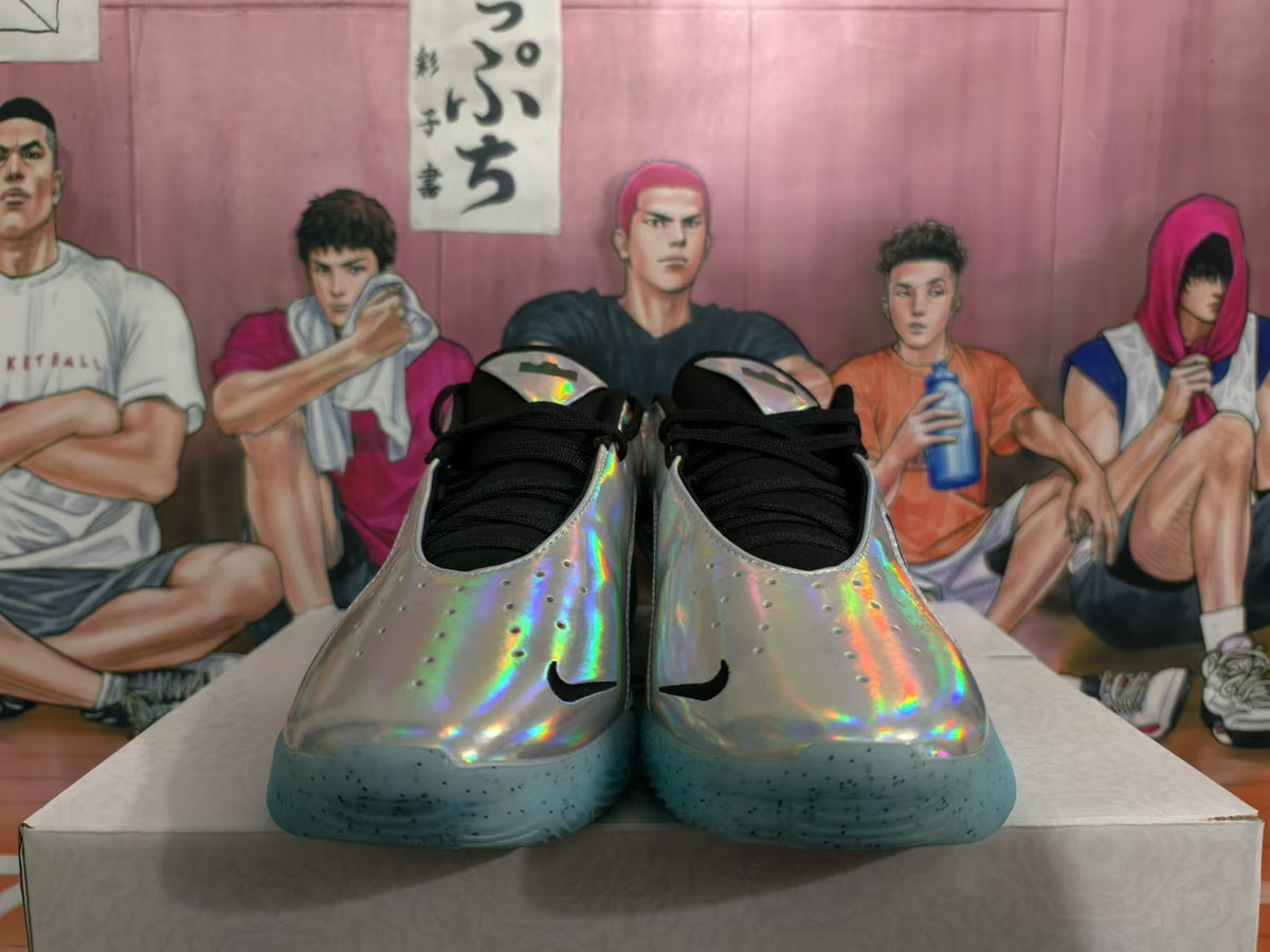 Front view of silver holographic basketball shoes with black laces and turquoise outsoles
