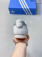 Rear view of the white sneaker with a silver heel tab and logo.