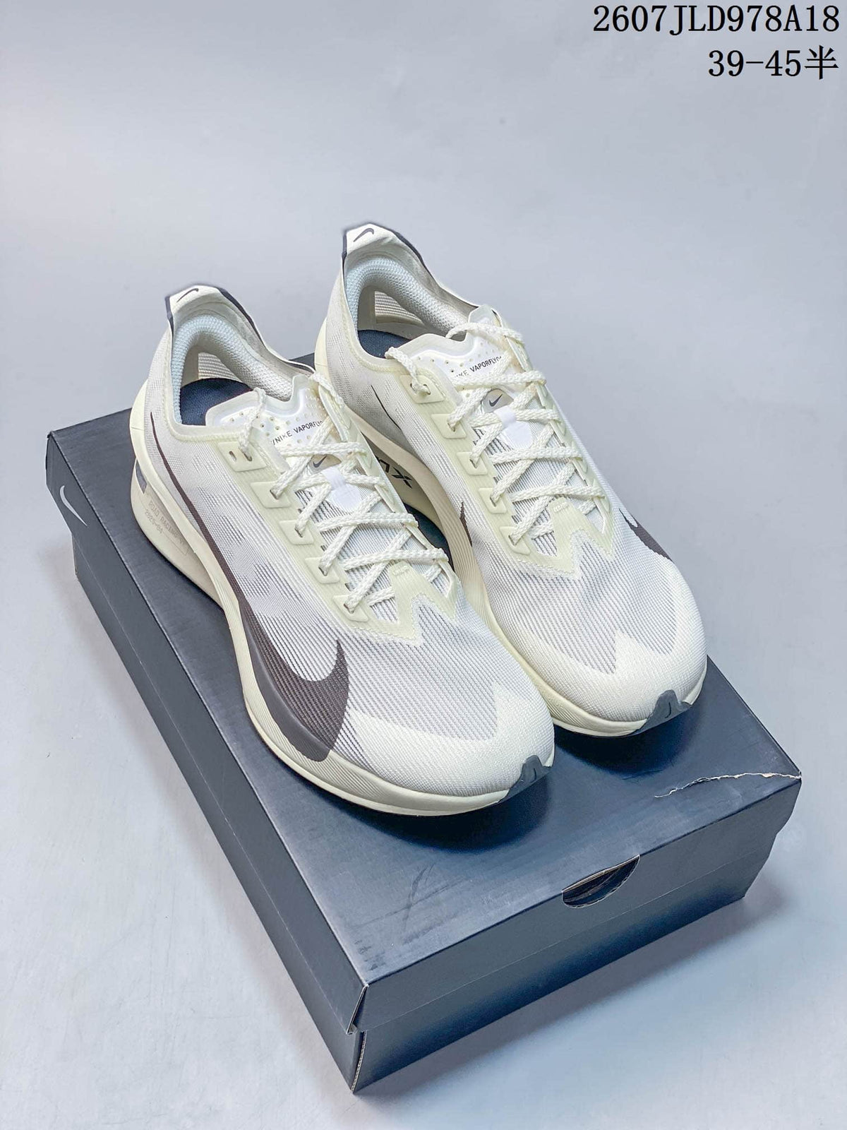 Pair of white and light cream Nike Vaporfly running shoes displayed on a Nike shoebox; overlay text shows product code 2607JLD978A18 and size range 39–45.5.