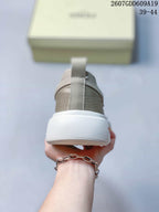 Rear view of the sneaker showing the heel pull tab, textured upper, and raised white sole.