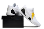 All-white shoes displayed on a black shoebox.
