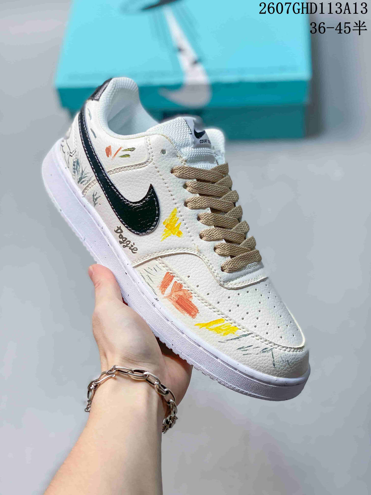 Angled side view showing the white upper, black Swoosh, beige laces, perforated toe box, and hand-drawn multicolor artwork.