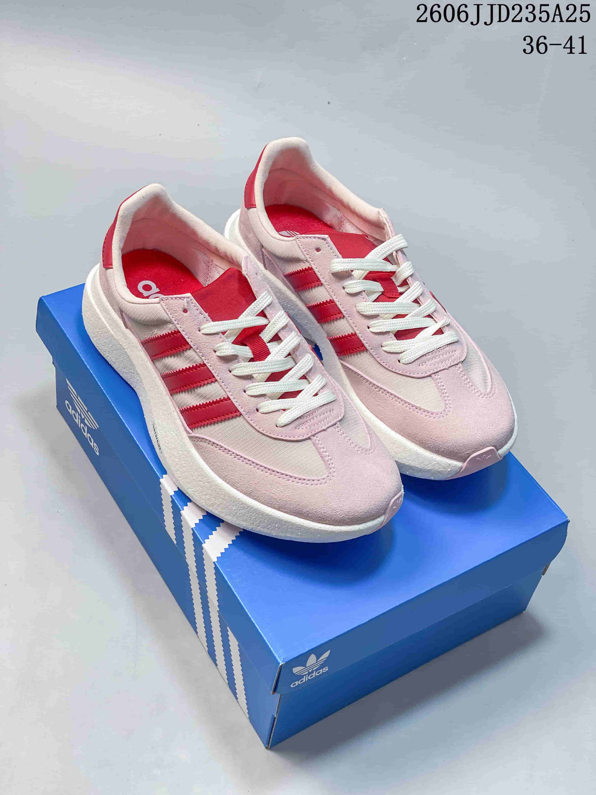 Pale pink Adidas Adizero SL 72 Pro sneakers with red stripes on a blue shoe box