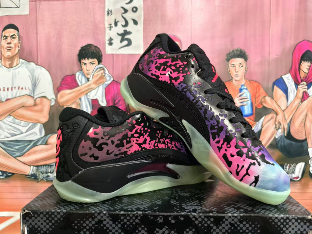 Pair of Jordan XXXVIII basketball shoes with black, pink, purple, and blue splatter-pattern uppers and translucent outsoles