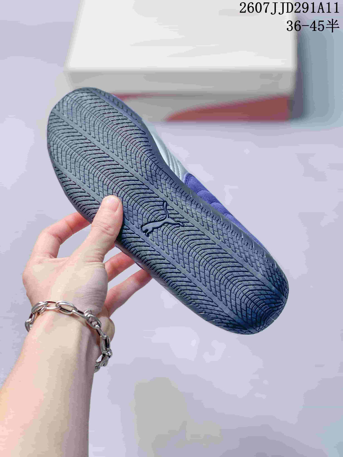 Underside of a purple sneaker showing the dark rubber outsole and its repeating tread pattern.