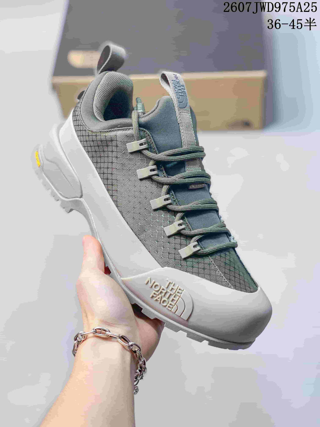 Three-quarter view of a gray The North Face trail sneaker showing the branding, lace closure, padded collar and rugged outsole.