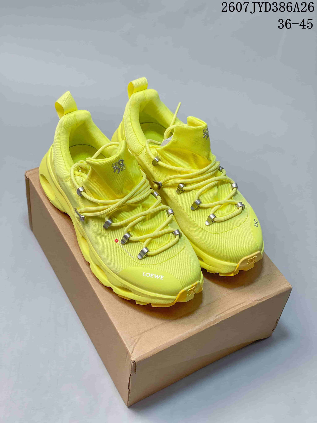 Pair of neon yellow On x LOEWE low-top sneakers displayed on a shoe box, with the style code and size range visible above.
