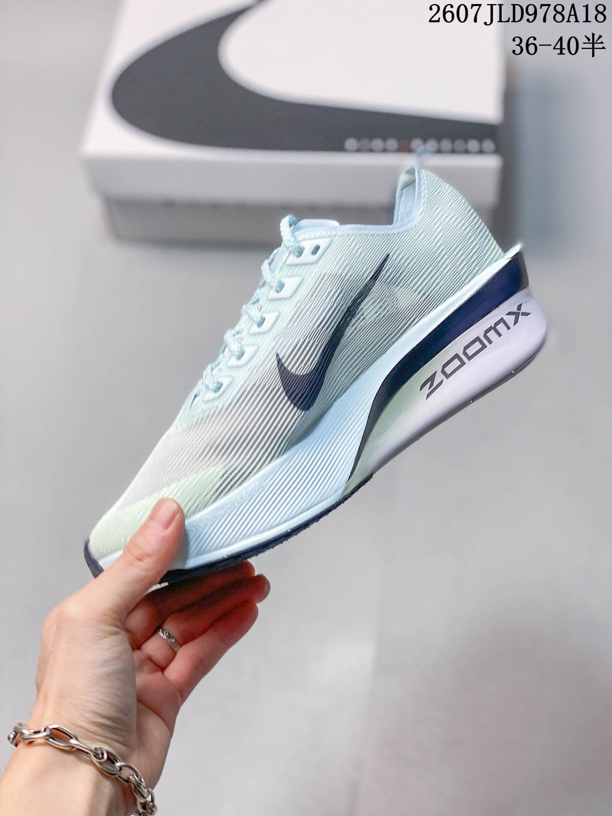 Side profile of the pale blue Nike running sneaker showing the large dark Swoosh and ZoomX-marked midsole.