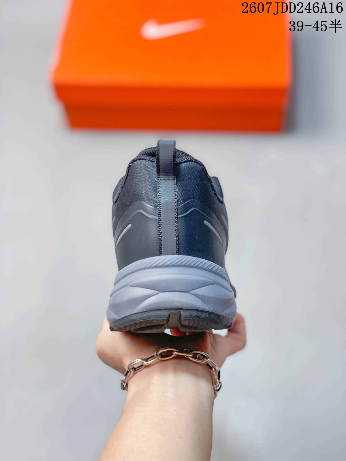 Rear view of the dark running shoe showing the heel pull tab, layered heel structure, and textured outsole.