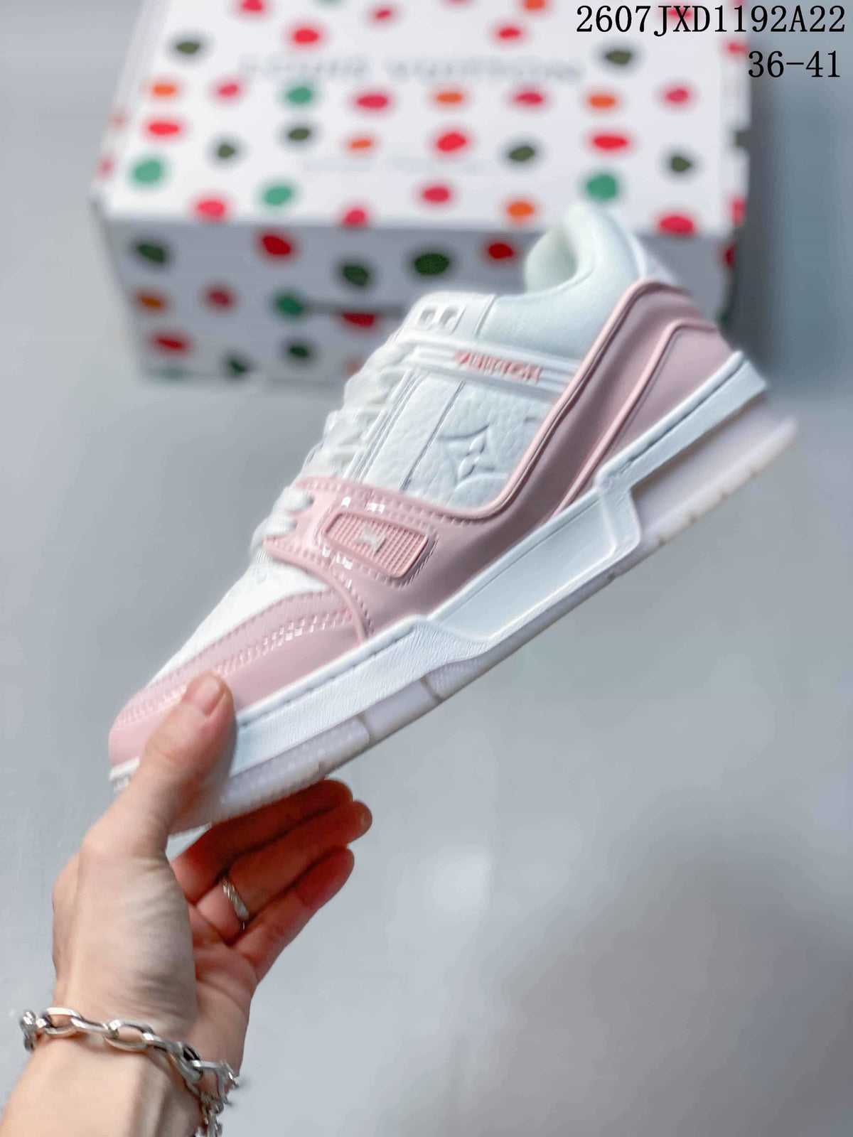 Side profile highlighting the white and pink panels, lace-up design and raised outsole.