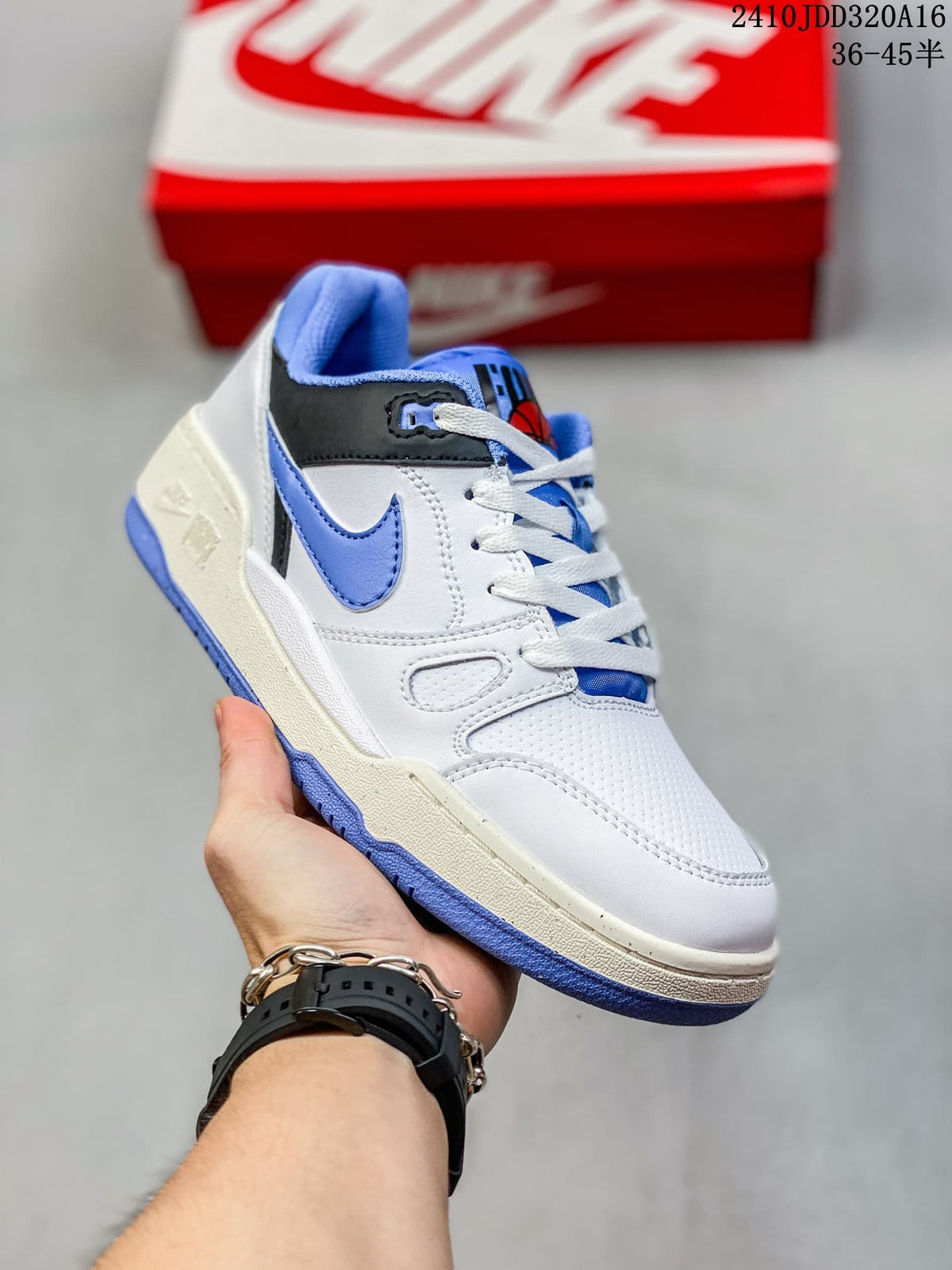 Angled side view of the Nike Full Force LO sneaker showing the white upper, blue Swoosh, black collar detail and textured blue outsole.