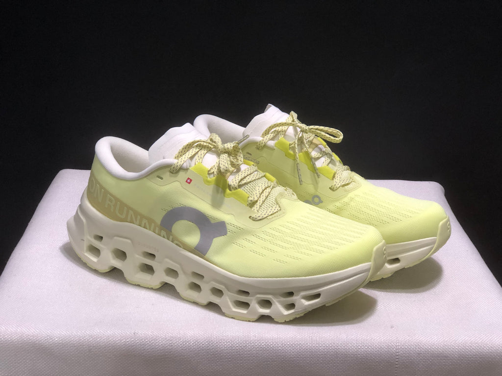 Three-quarter front view of the light yellow and white running sneakers.