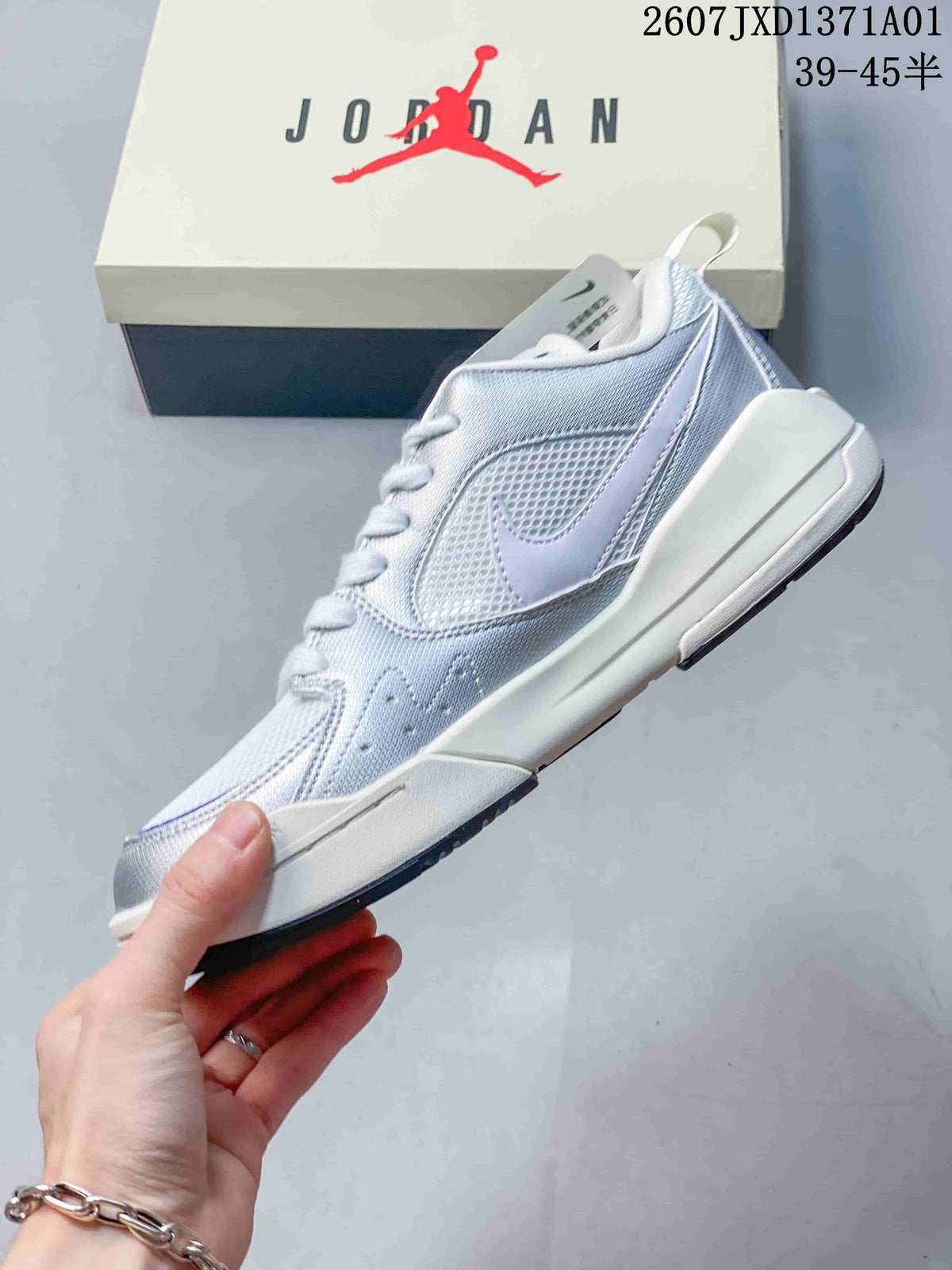 Side view of a white and silver low-top sneaker with mesh-style panels and blue accents.