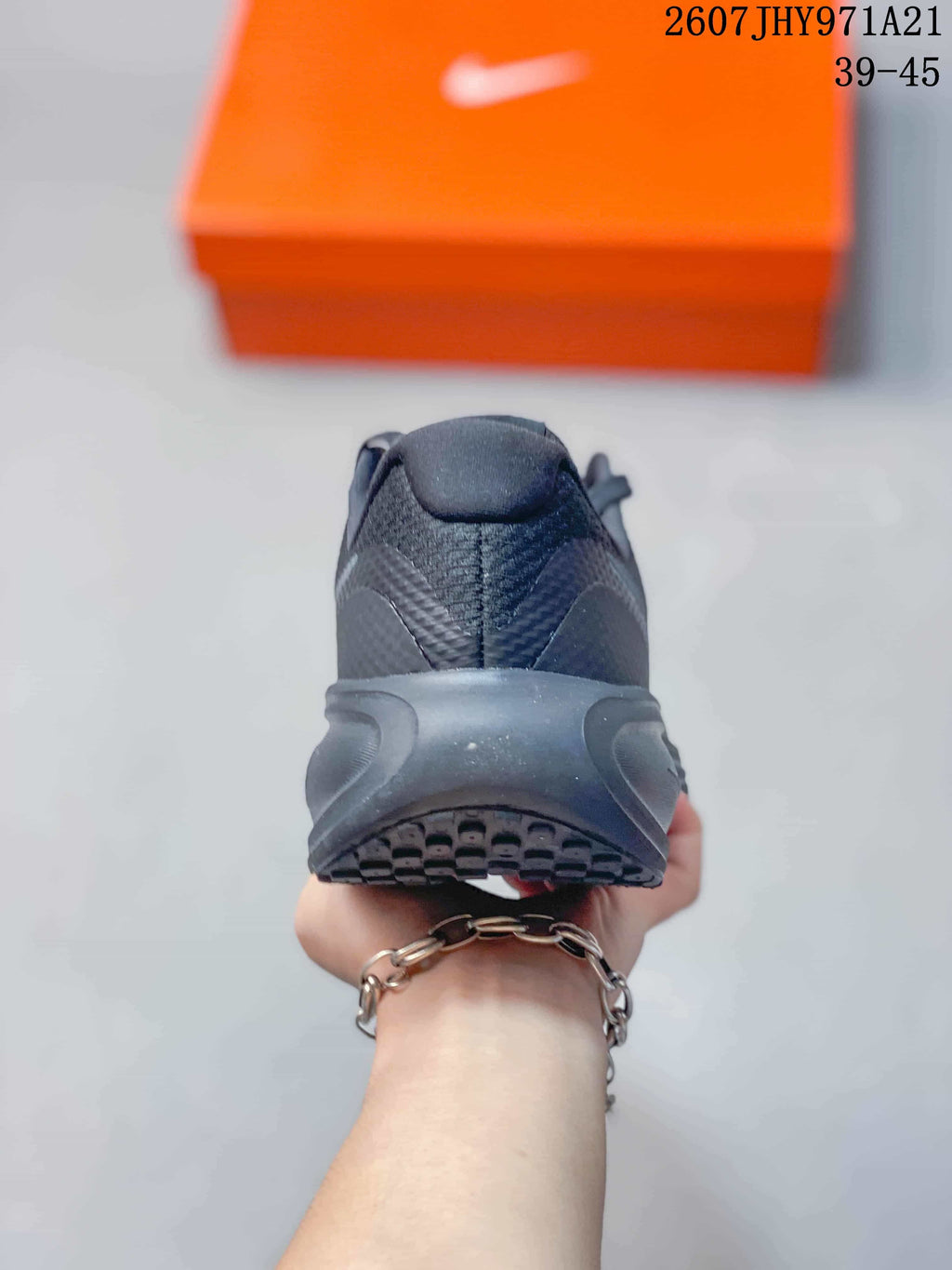 Rear view of the black sneaker showing the padded heel, layered midsole, and outsole tread.