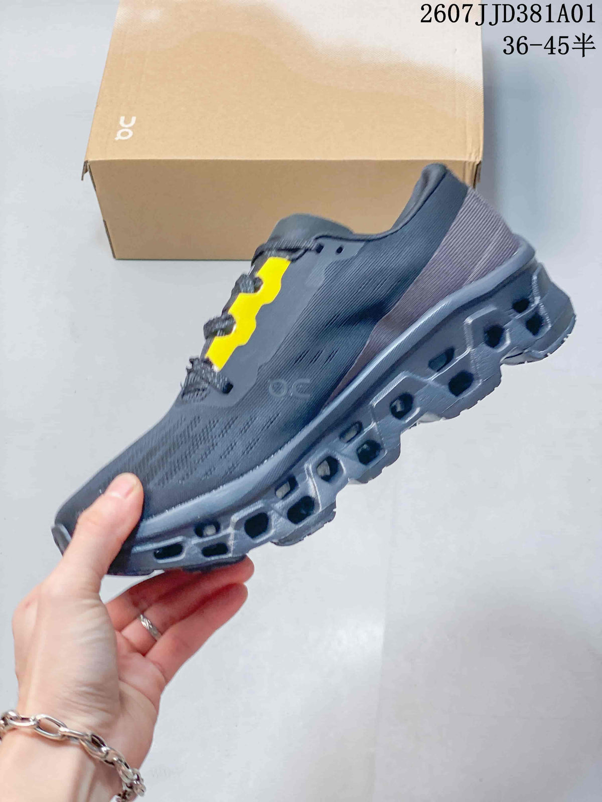 Side profile of a dark grey running shoe with yellow lace accents and a podded sole.