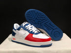 Angled view showing the blue patterned outsole beneath the white, blue, and red sneaker.
