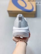 Rear view of the white and gray running shoe showing the padded heel, striped pull tab, and layered outsole.