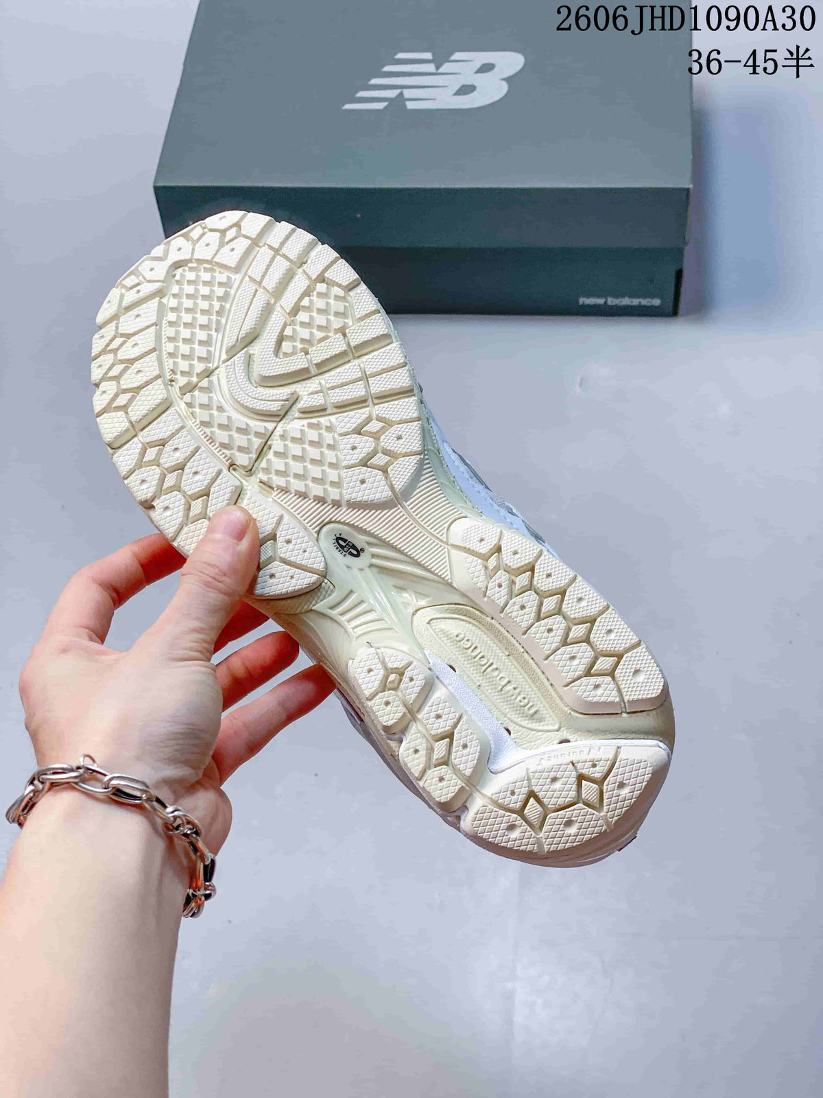 Close-up of the cream-colored patterned outsole of a New Balance M1906R sneaker.