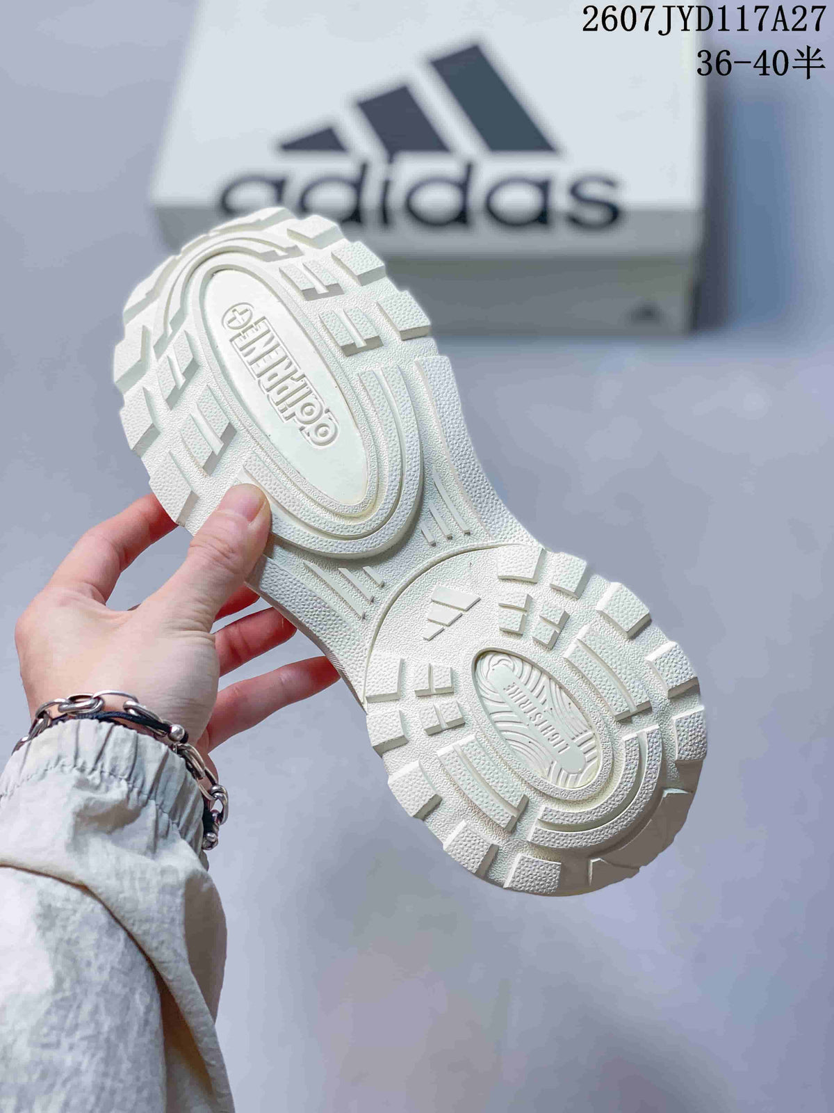 Close view of the white patterned outsole with raised adidas branding and textured tread.