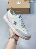 Close-up of a white and gray low-top sneaker with blue side emblem and laces