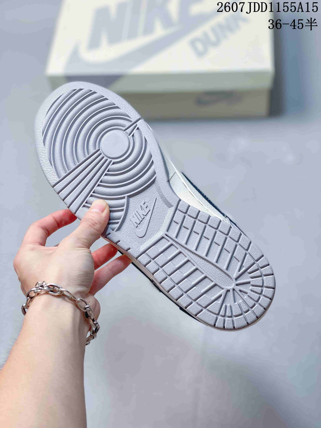 Close view of the gray rubber outsole with circular traction at the forefoot and rectangular tread blocks at the heel.
