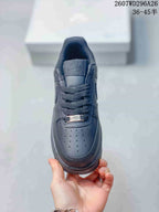 Top view of a black sneaker showing the perforated toe box, woven laces, tongue branding, and metal lace tag.
