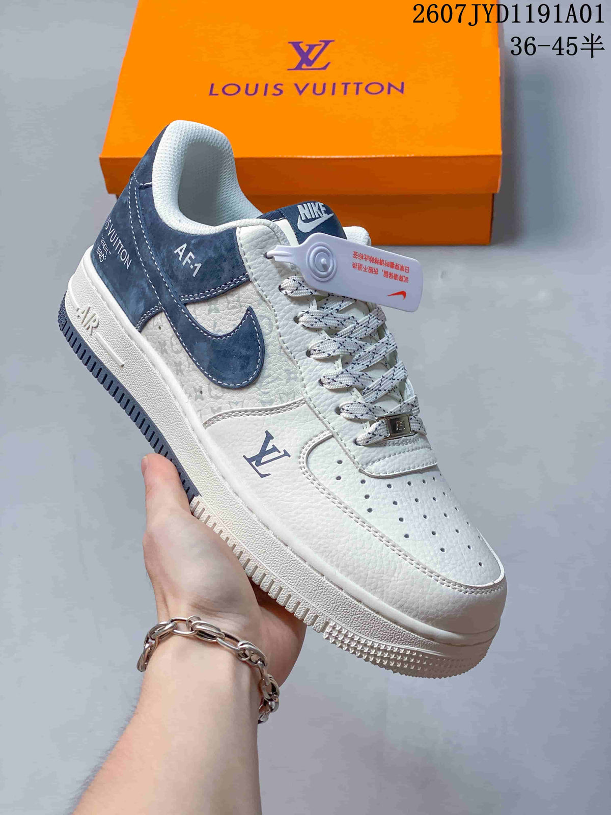 Angled side view of the white and navy sneaker with visible side and heel branding.