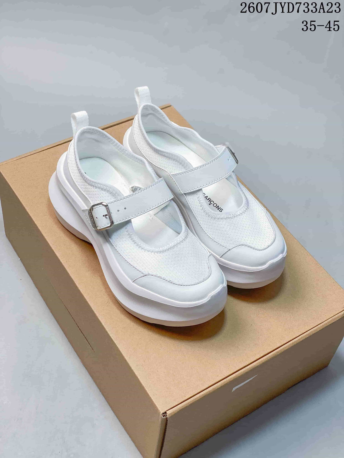 Pair of white Mary Jane-style sneakers with chunky platform soles shown on a box.